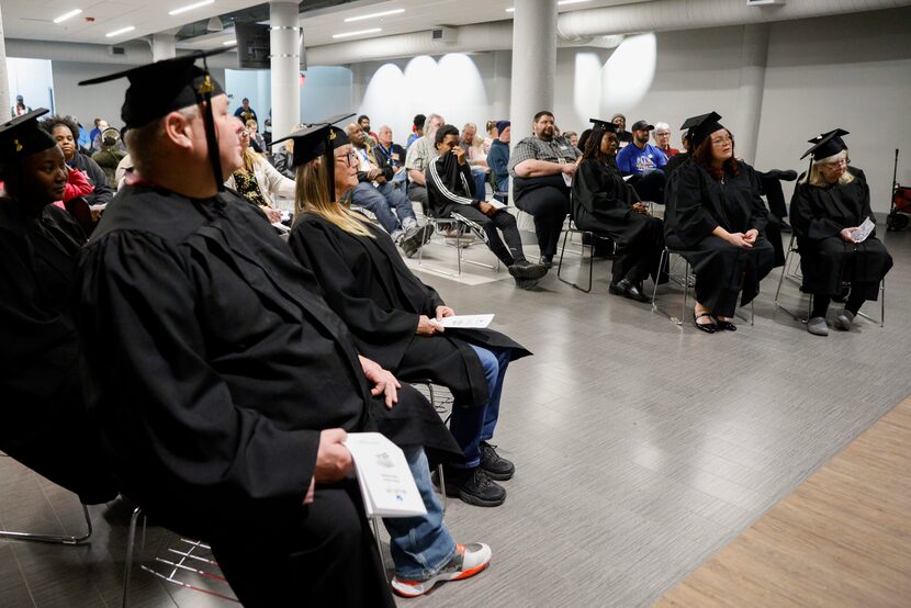 Homeless No More Program graduates listen as the Rev. Bob Sweeney speaks during a graduation...