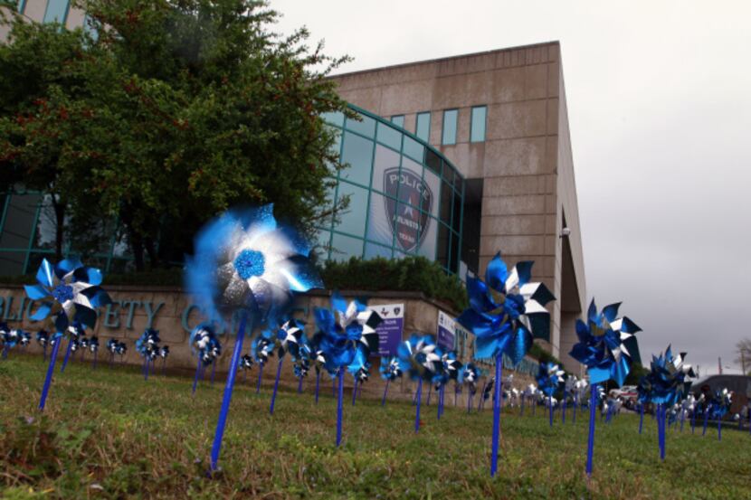 Pinwheels whir on the lawn of the Arlington police headquarters in downtown Arlington. Each...