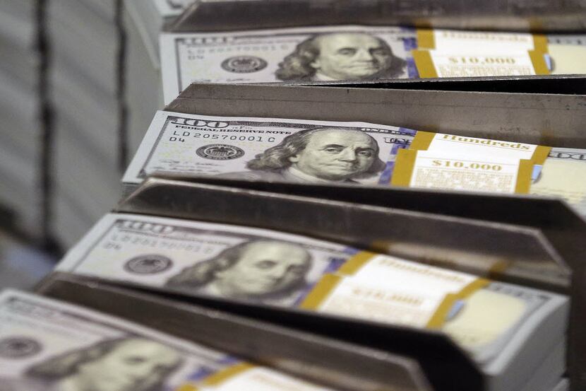 FILE - In this Sept. 24, 2013 file photo, freshly cut stacks of $100 bills make their way...
