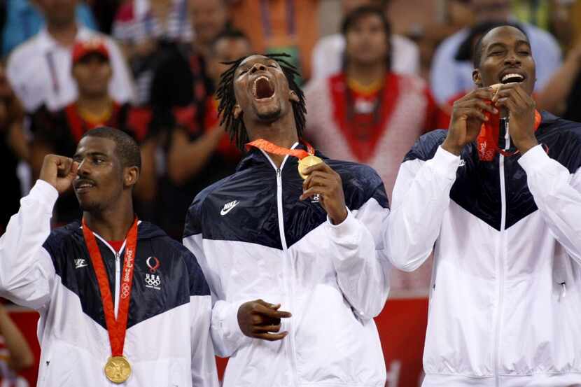 USA men's basketball player Chris Bosh of Dallas (center) celebrates with his gold medal...
