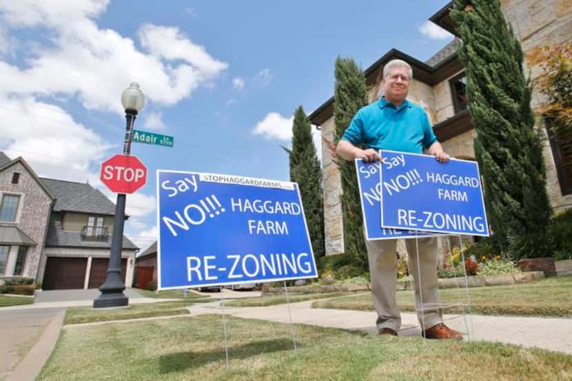 
Steve Lavine holds signs protesting the proposed rezoning of a 329-acre site in West Plano...