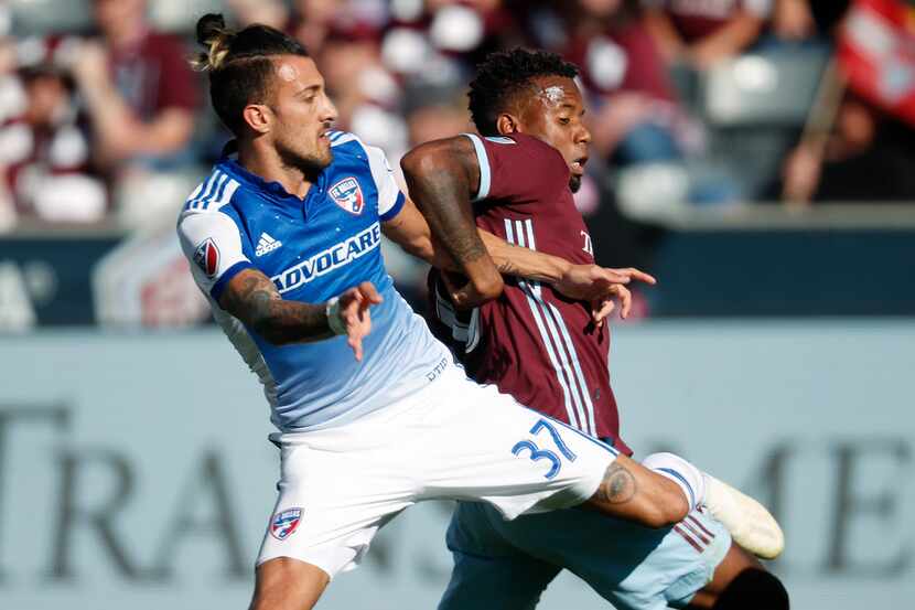 FC Dallas forward Maximiliano Urruti, left, becomes entangled with Colorado Rapids...