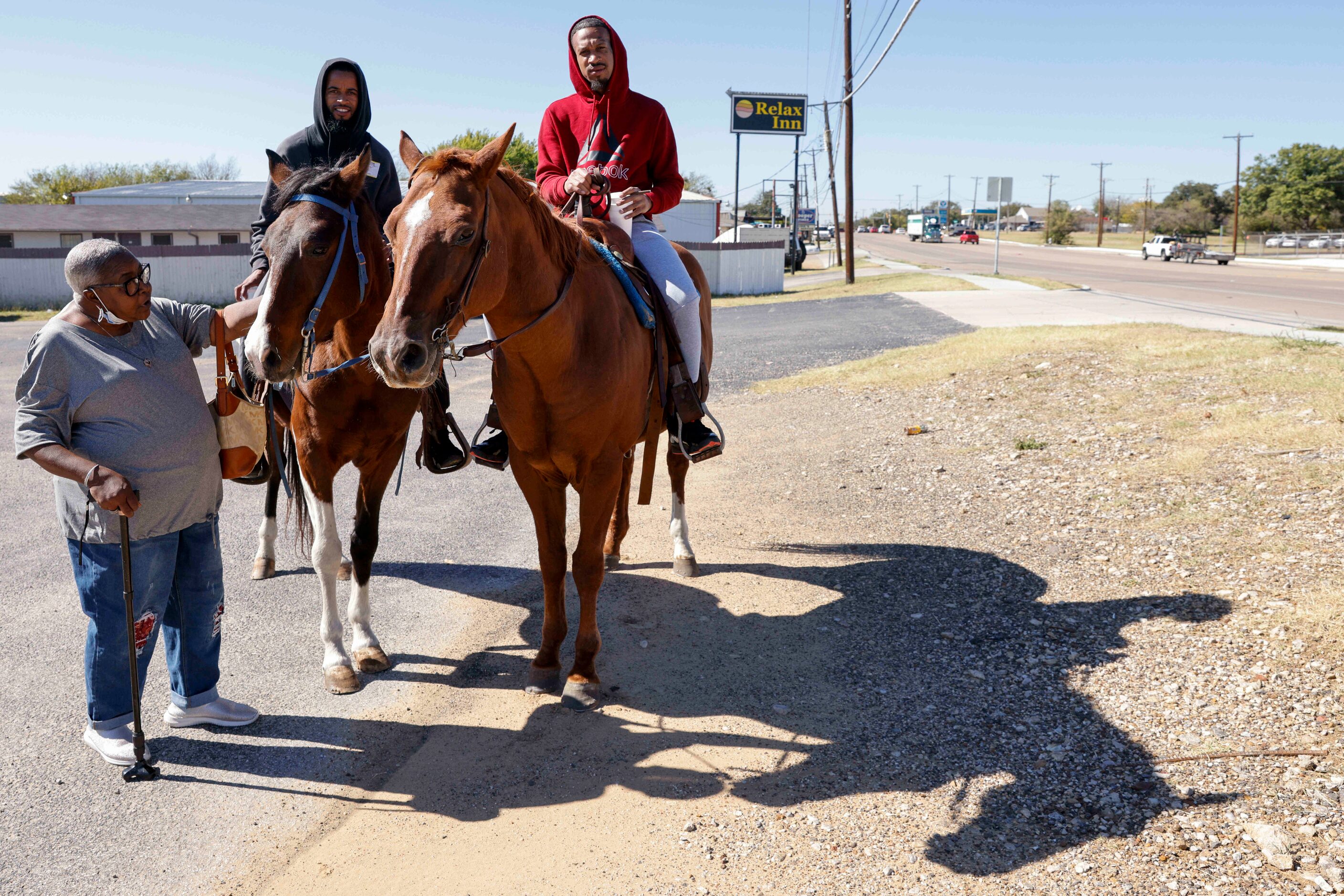 Cynthia Nickles, 62, of Forest Hill, pets Deuce as Bobby Dow (center) and Markel Walker on...