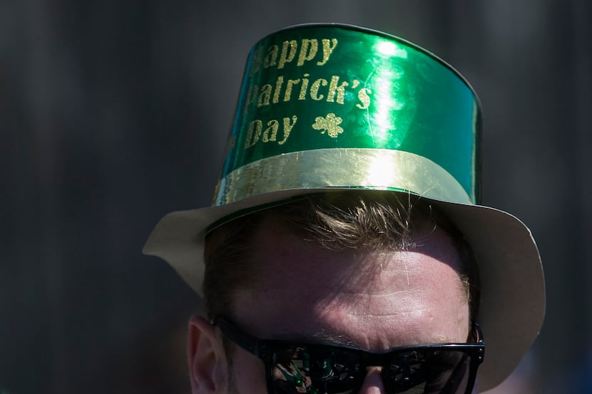 A man wearing a hat that says "Happy St. Patrick's Day" during the Lower Greenville Avenue...