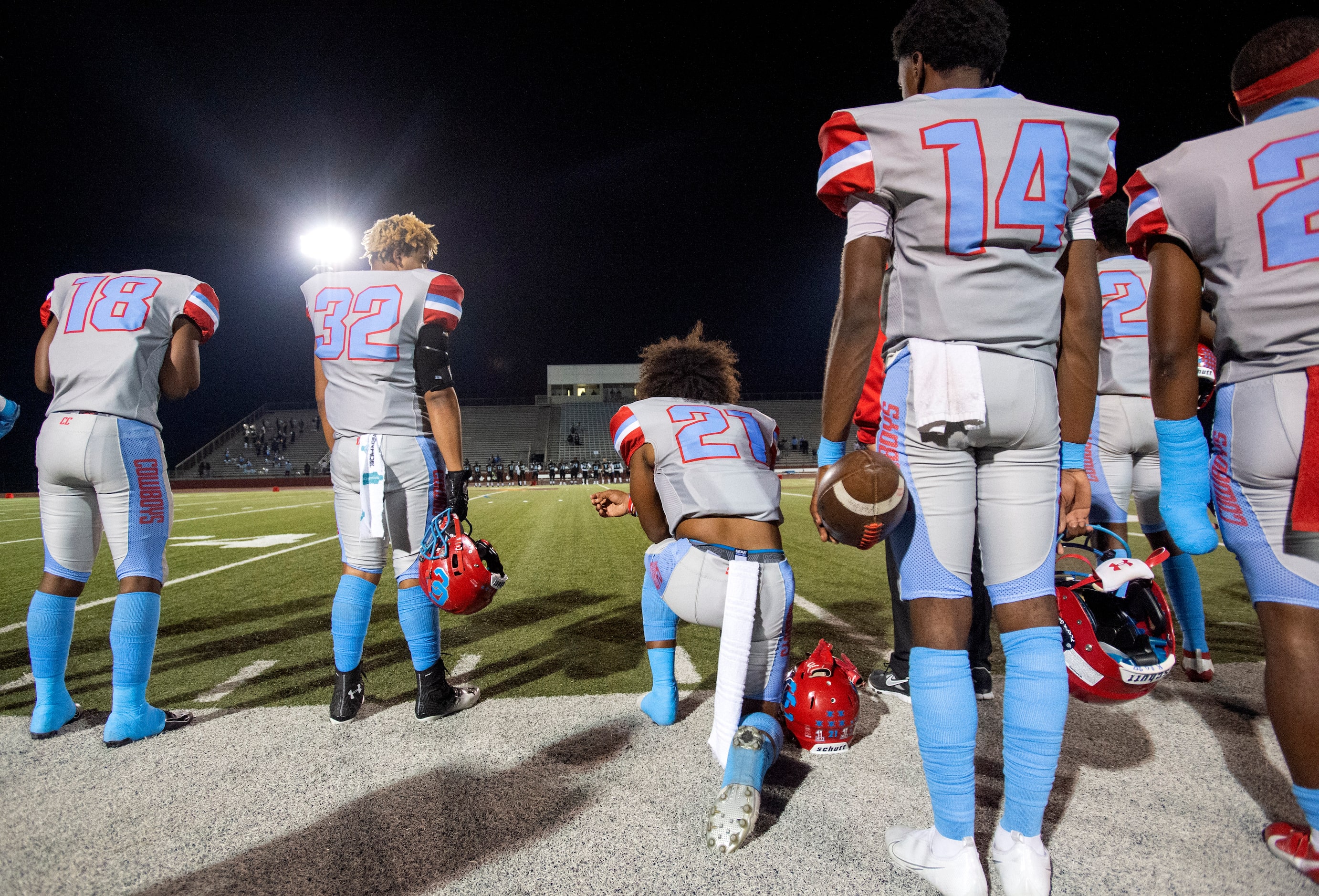 Carter senior defensive back Dartagnan Walker (21) takes a knee during the national anthem...