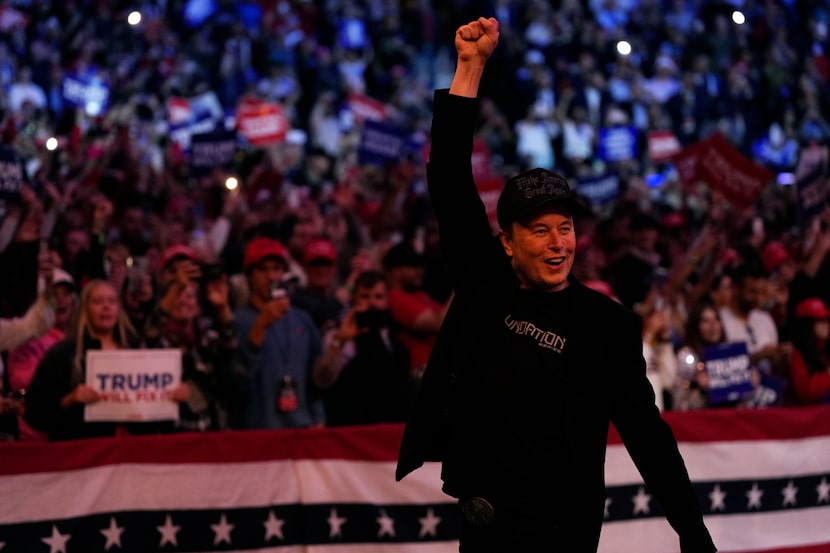 Elon Musk holds his fist in the air at a campaign rally for Republican presidential nominee...