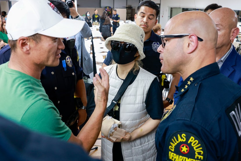 A victim of the Hair World Salon shooting (center) speaks with Dallas police Chief Eddie...