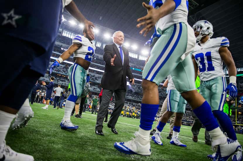 Dallas Cowboys owner and general manager Jerry Jones, center, high fives players as they...