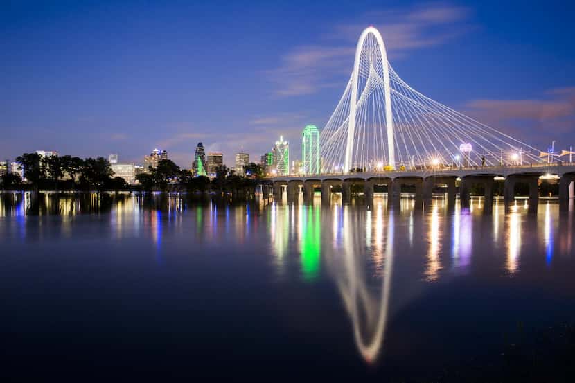 The downtown Dallas skyline and the Margaret Hunt Hill Bridge rise over the Trinity River,...