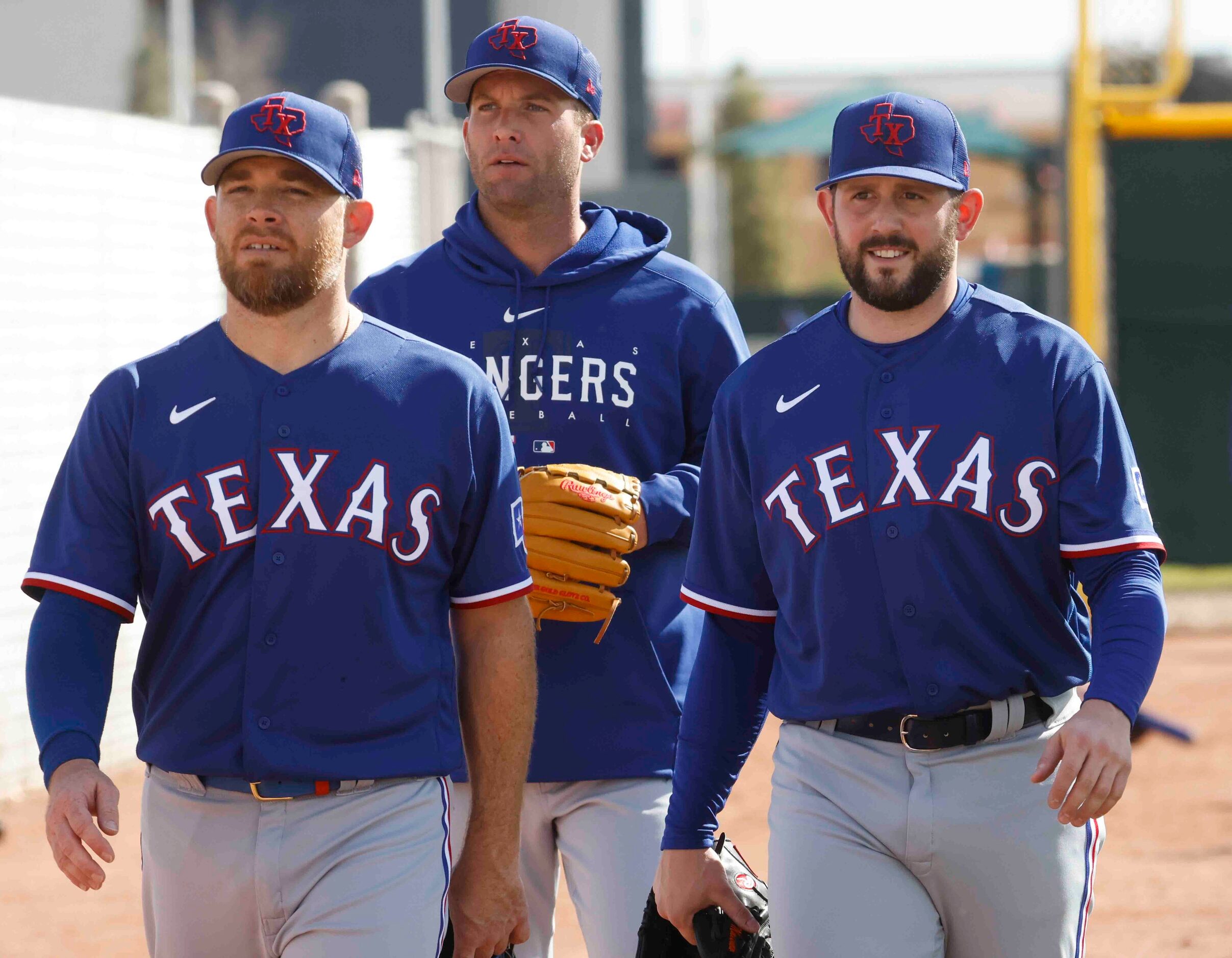 Texas Rangers pitchers Ian Kennedy, left, Danny Duffy, center, and Dominic Leone head to a...