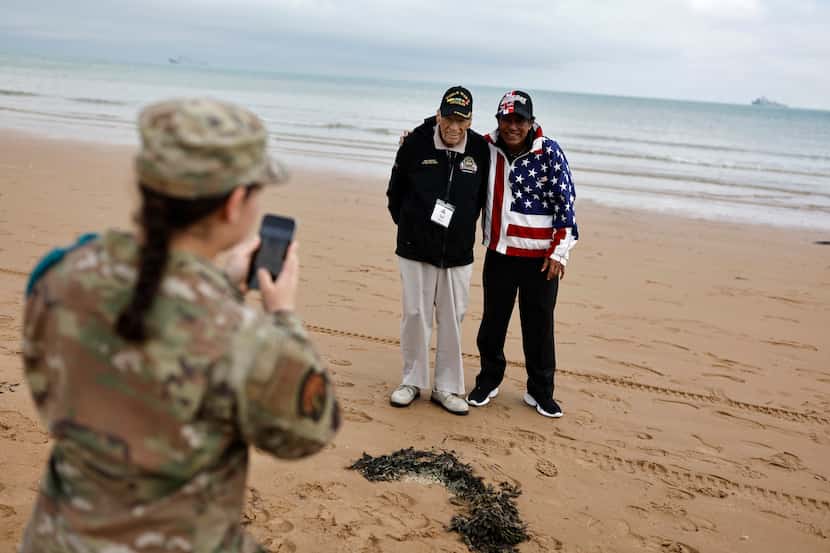 A U.S. soldier takes a photograph of American World War II veteran Sid Edson (left) during a...