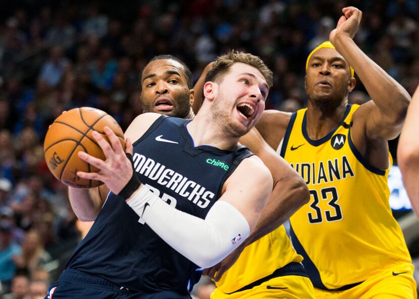 Dallas Mavericks guard Luka Doncic (77) is fouled by Indiana Pacers forward T.J. Warren (1)...