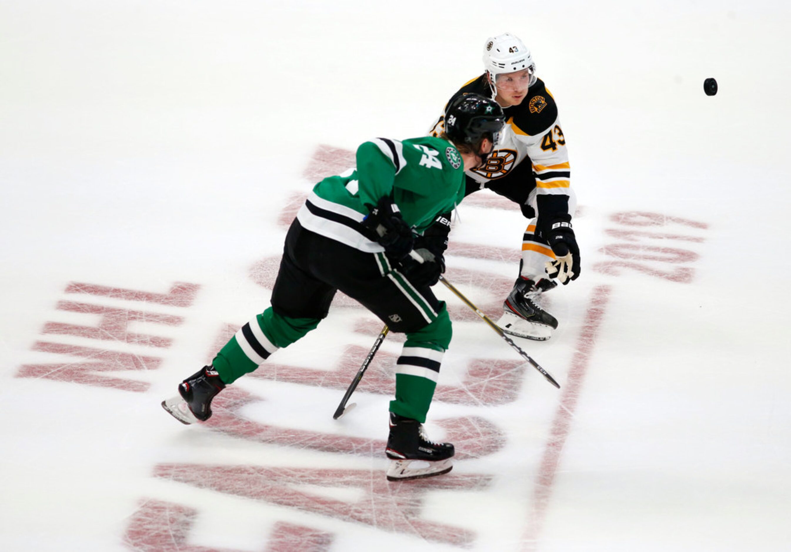 Dallas Stars left wing Roope Hintz (24) and Boston Bruins center Danton Heinen (43) go after...