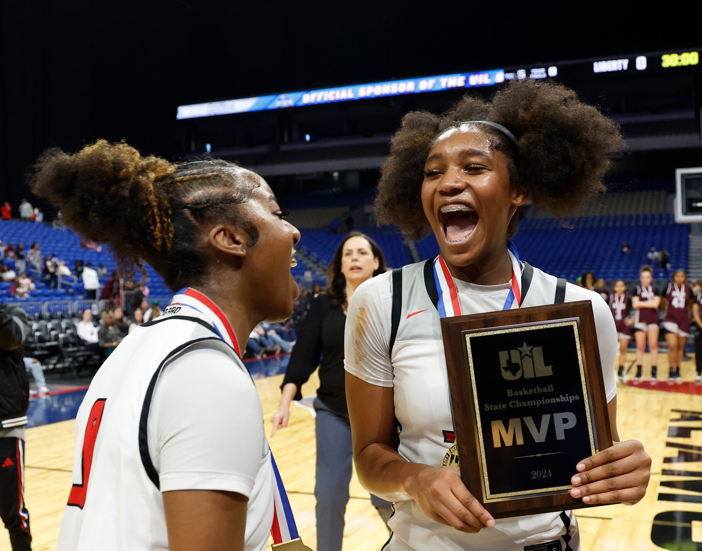 Frisco Liberty's Jacy Abii (3) is hugged by teammate Aziyah Farrier (0) after being named...