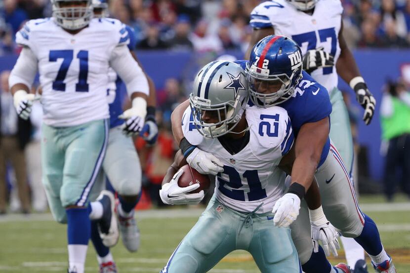 Dallas Cowboys running back Joseph Randle (21) is tackled by New York Giants defensive end...