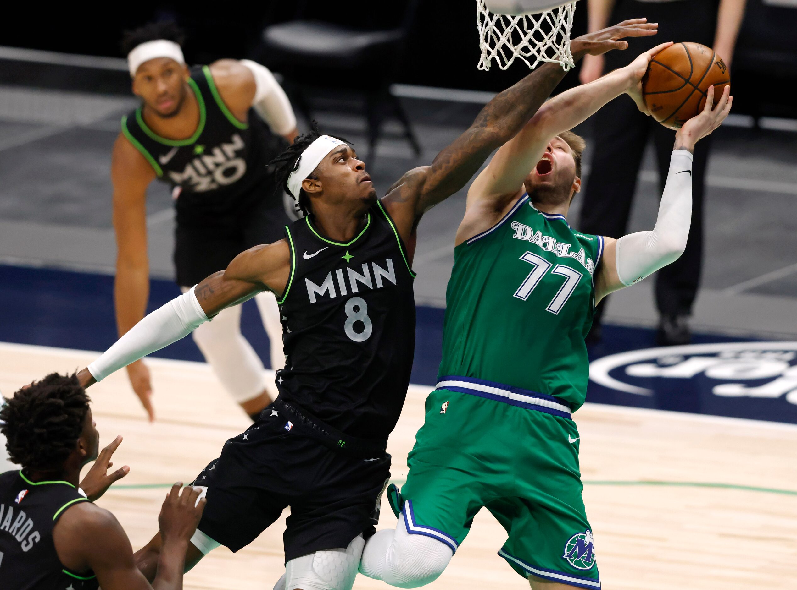 Dallas Mavericks guard Luka Doncic (77) is fouled as he shoots over Minnesota Timberwolves...