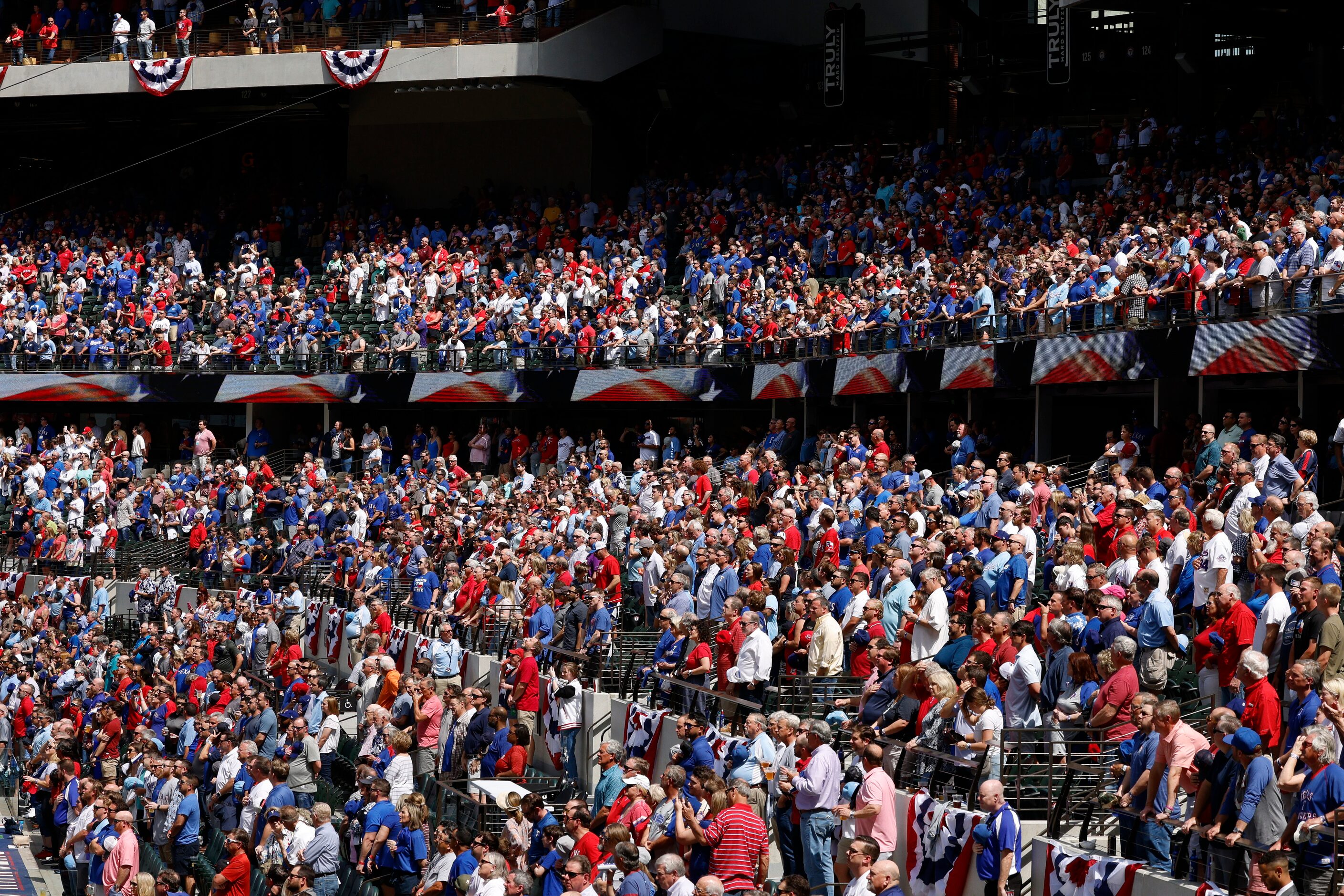 Baseball fans stand for the national anthem before the Texas Rangers’ home opener against...