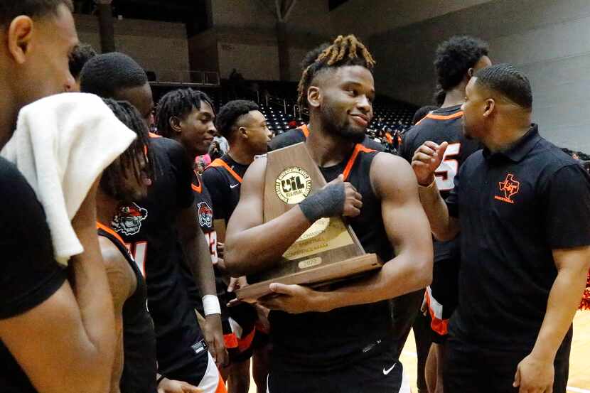 Lancaster High School guard Mike Miles (1) checks out the trophy after the win as Kimball...