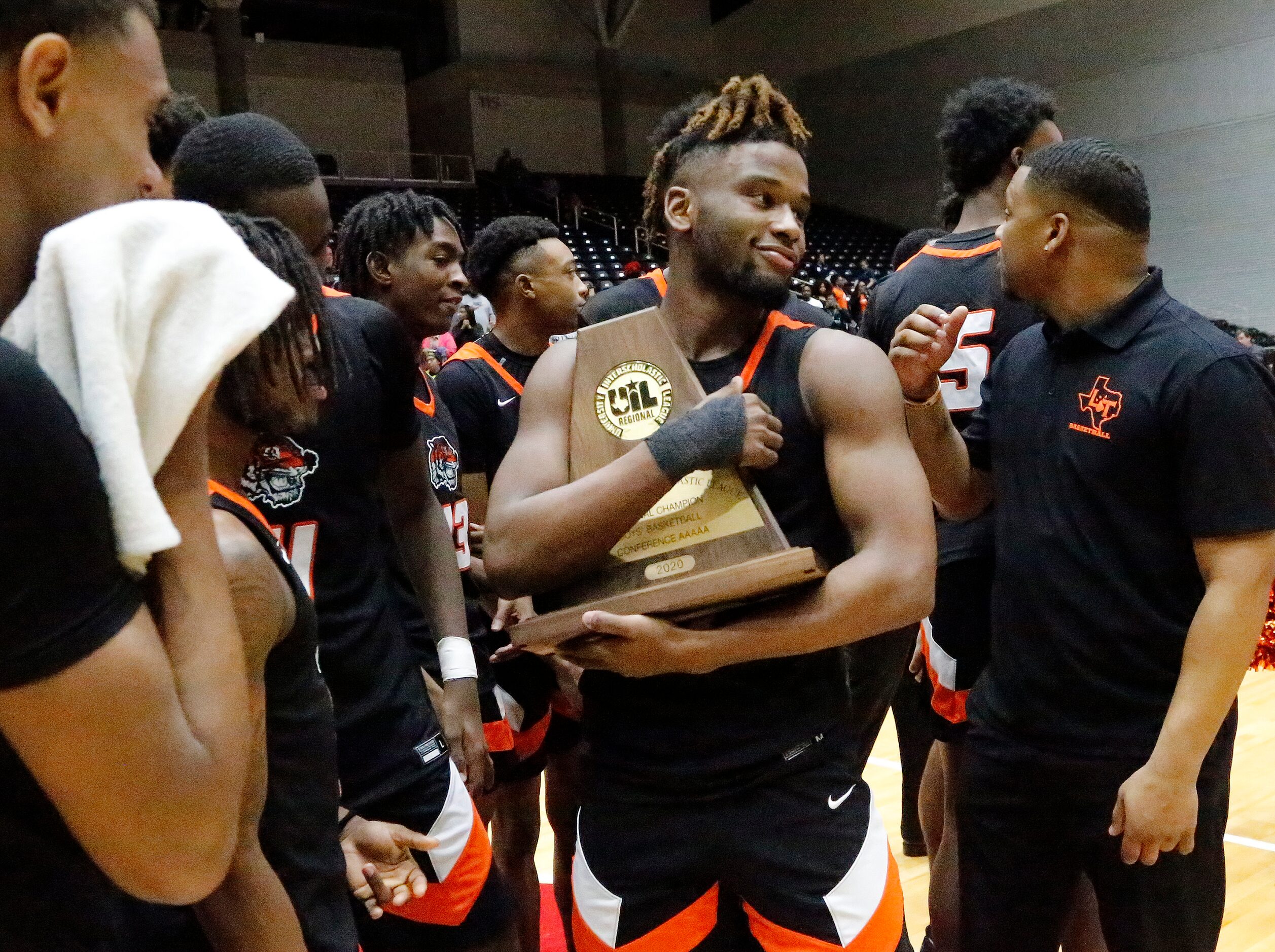 Lancaster High School guard Mike Miles (1) checks out the trophy after the win as Kimball...