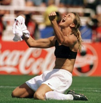  Brandi Chastain celebrates by taking off her jersey after kicking in the game-winning...