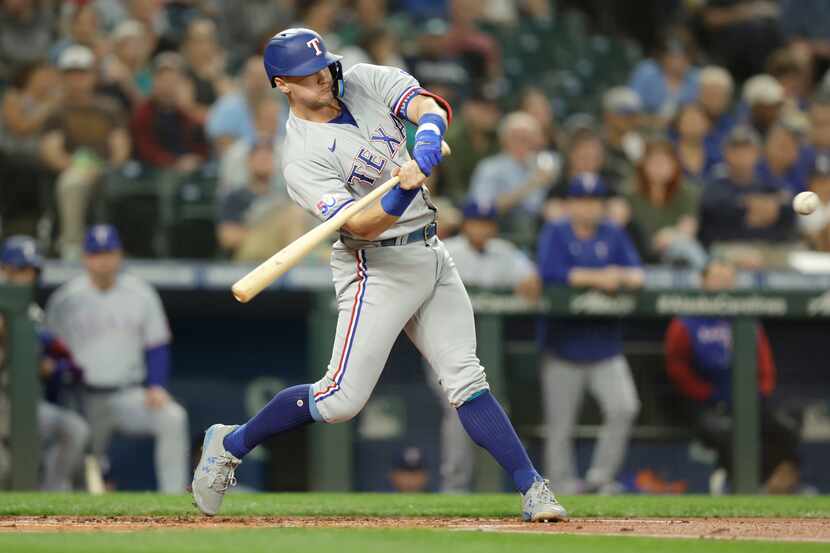 Texas Rangers' Josh Jung swings into a pitch and hits a solo home run on a pitch from...