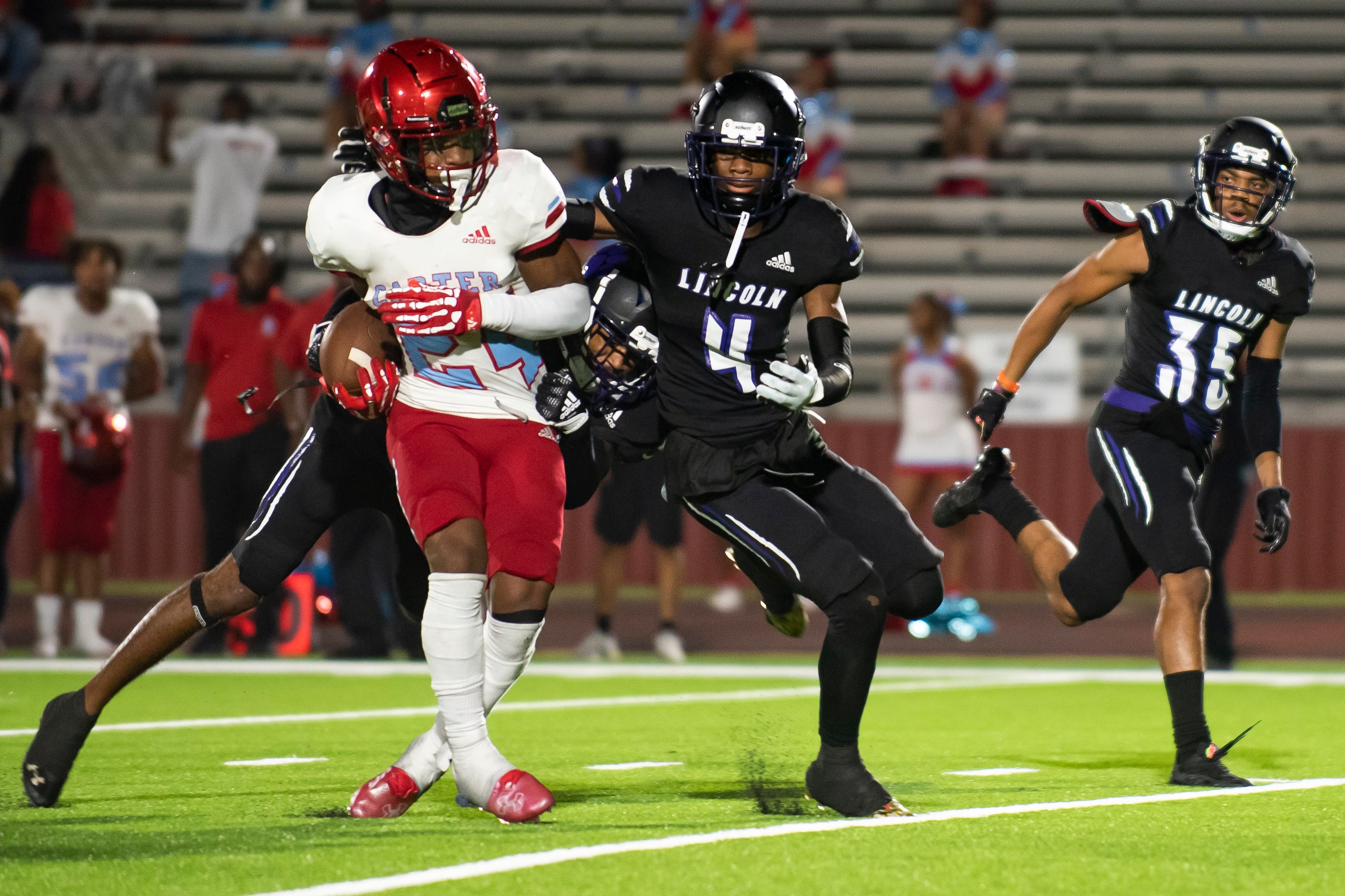 Carter junior Kaeden Landry (24) sheds tackles by Lincoln defenders to rush down the field...