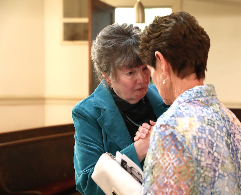 Marcia Cheatham (left) and Carolyn Murphy clasp hands and touch foreheads after the last...