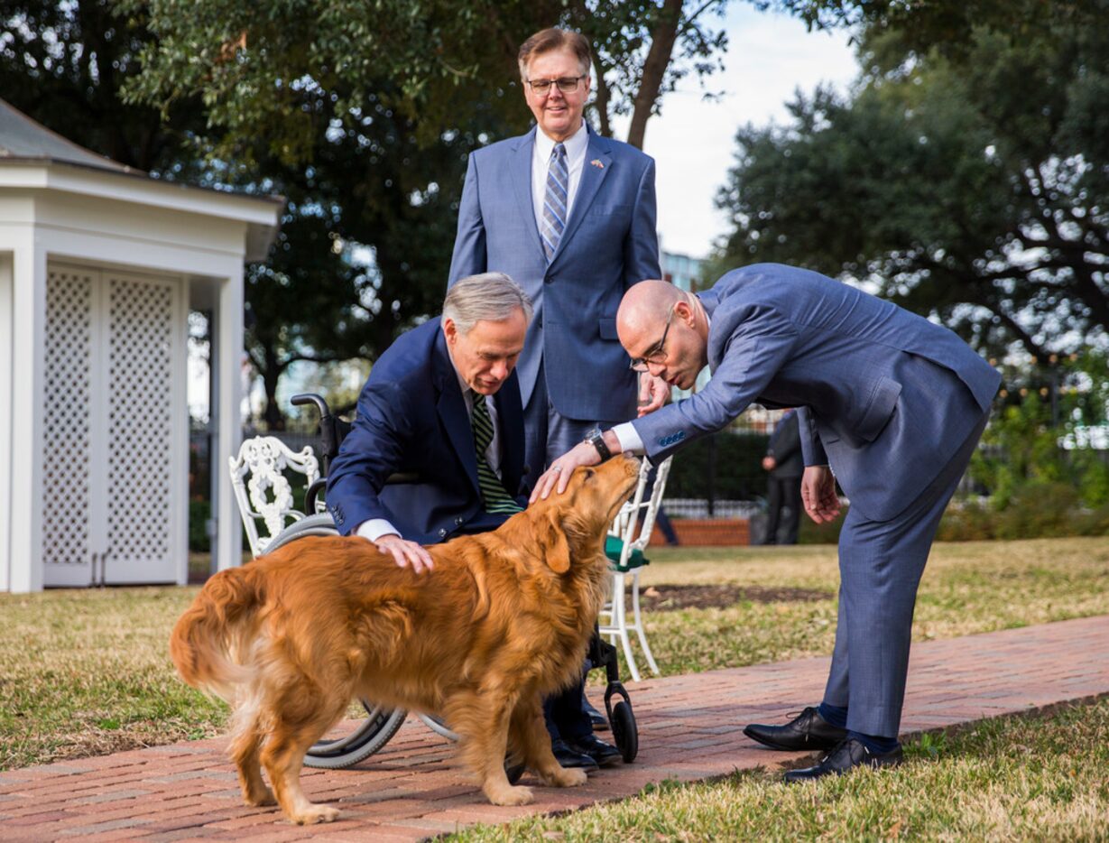 Gov. Greg Abbott, Lt. Gov. Dan Patrick and Speaker of the House Dennis Bonnen pet one of the...