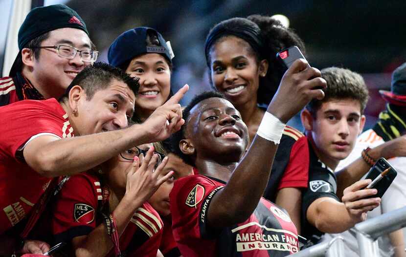 Atlanta United defender George Bello takes a selfie with fans after an MLS soccer match...