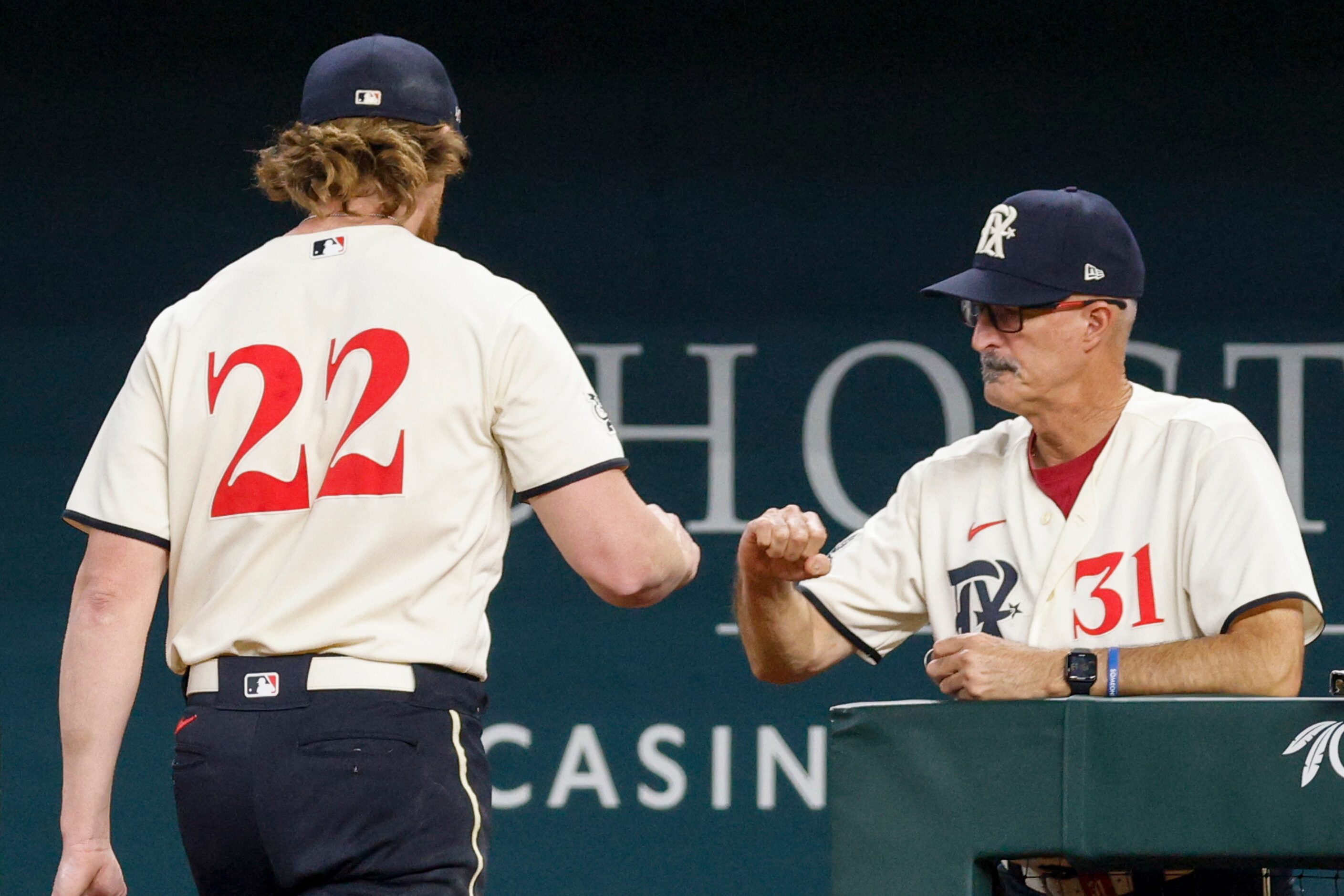 Texas Rangers starting pitcher Jon Gray (22) fist bumps pitching coach Mike Maddux (31)...