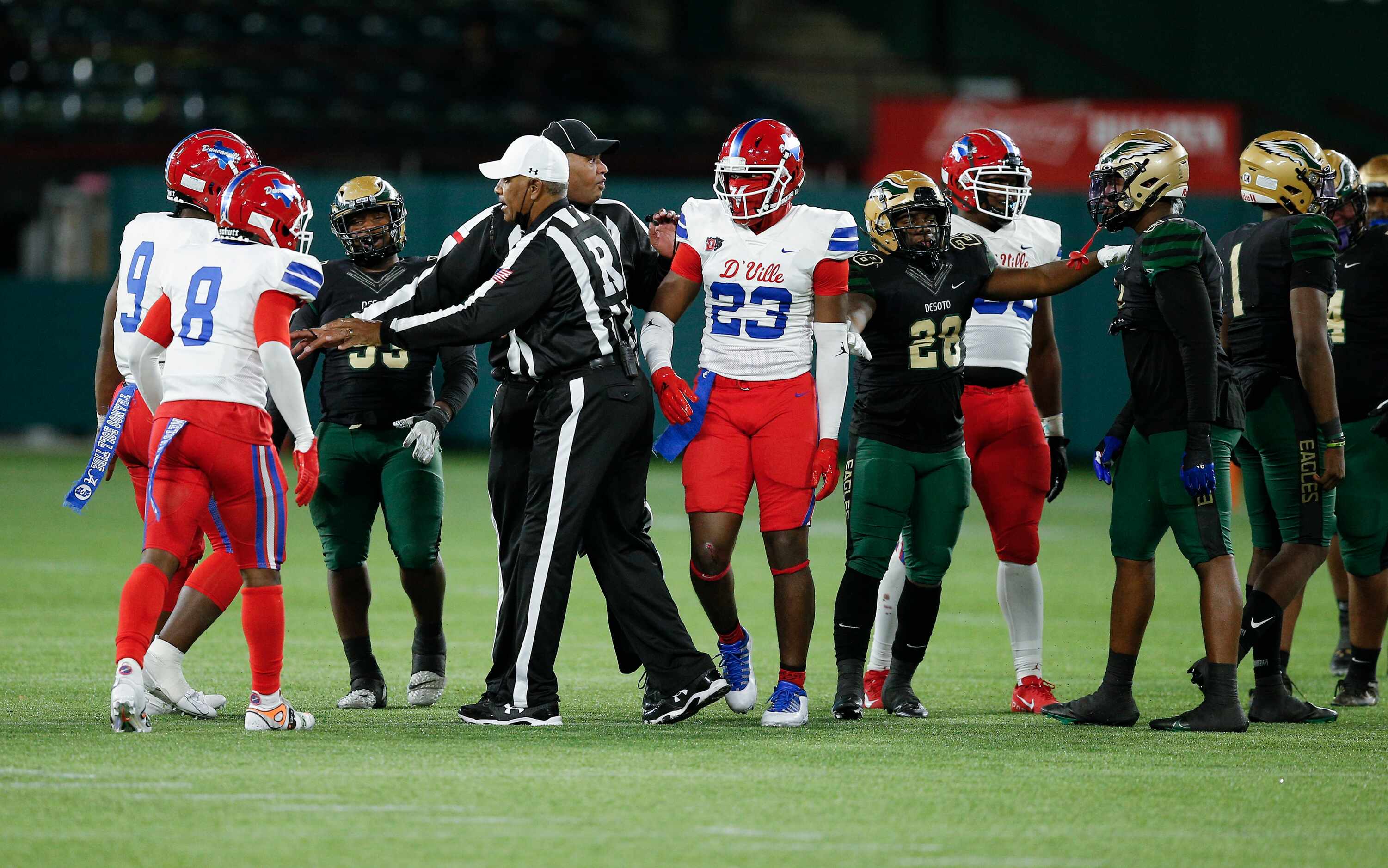 Referees separate Duncanville and DeSoto players after a skirmish between plays during the...