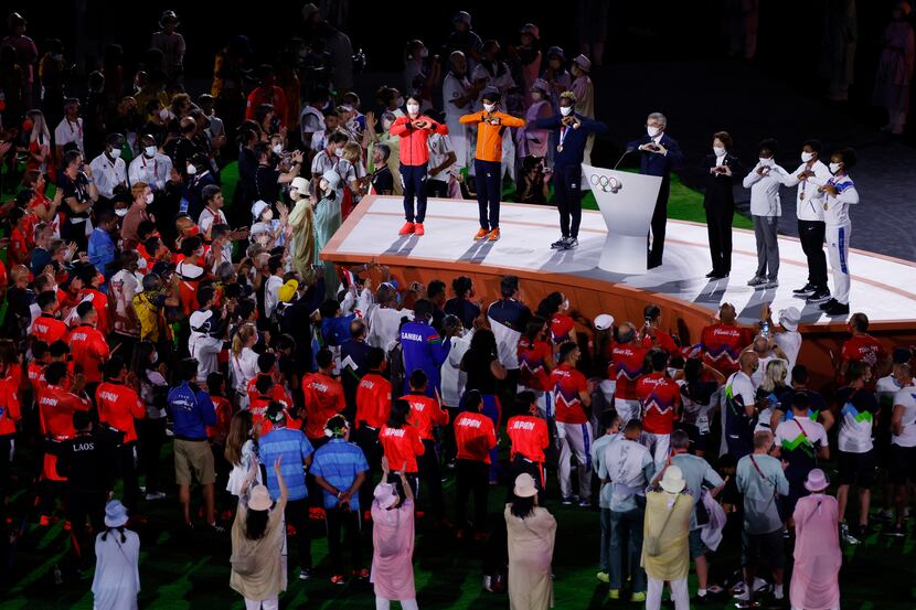 IOC president Thomas Bach signals a heart with others after giving his speech during the...