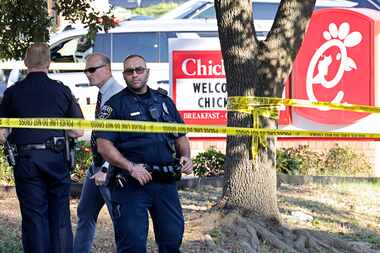 Police investigate in front of a Chick-fil-A at the scene of a shooting, Wednesday, June 26,...