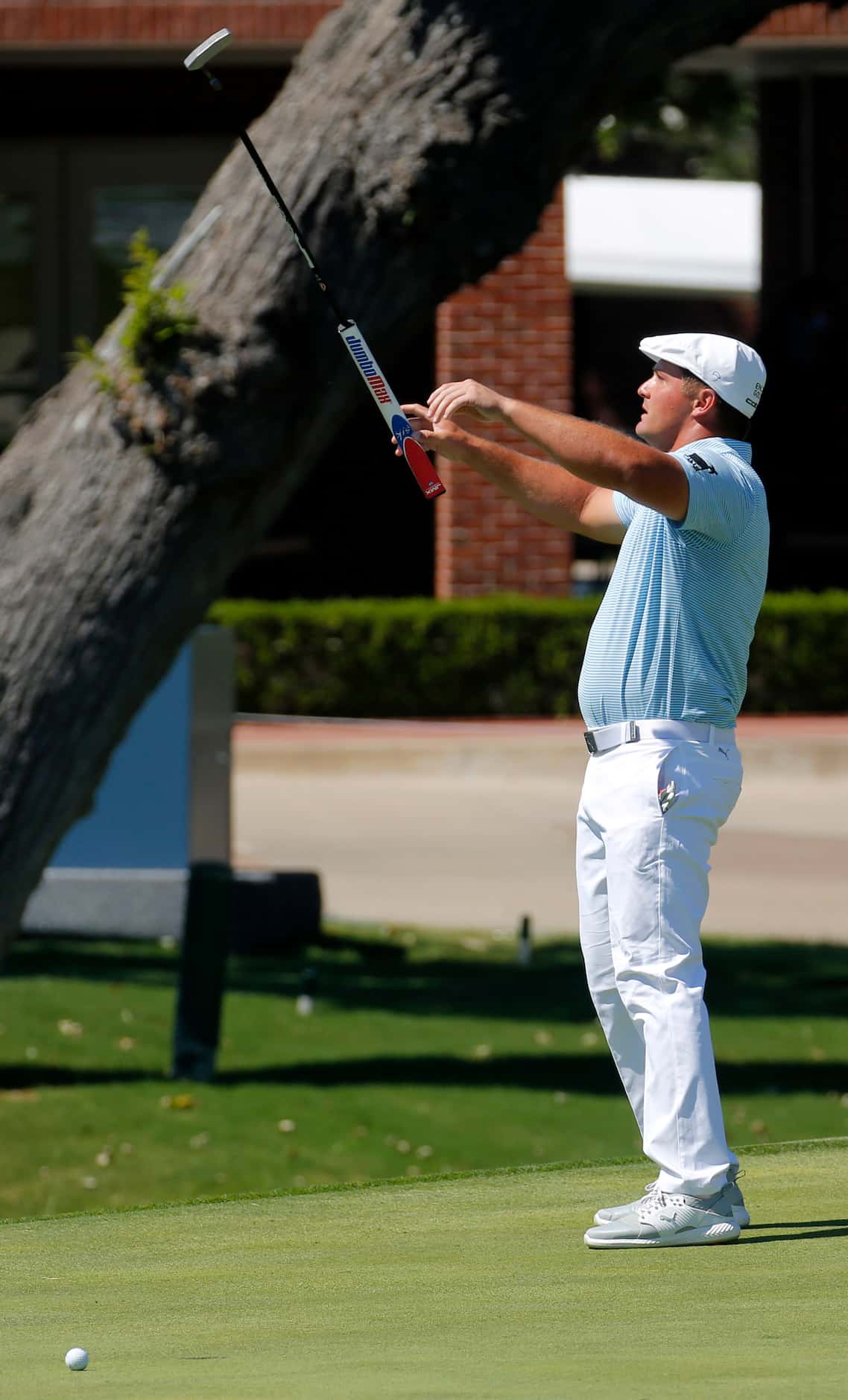 PGA Tour golfer Bryson DeChambeau
tosses his putter as he misses a birdie putt on No. 18...