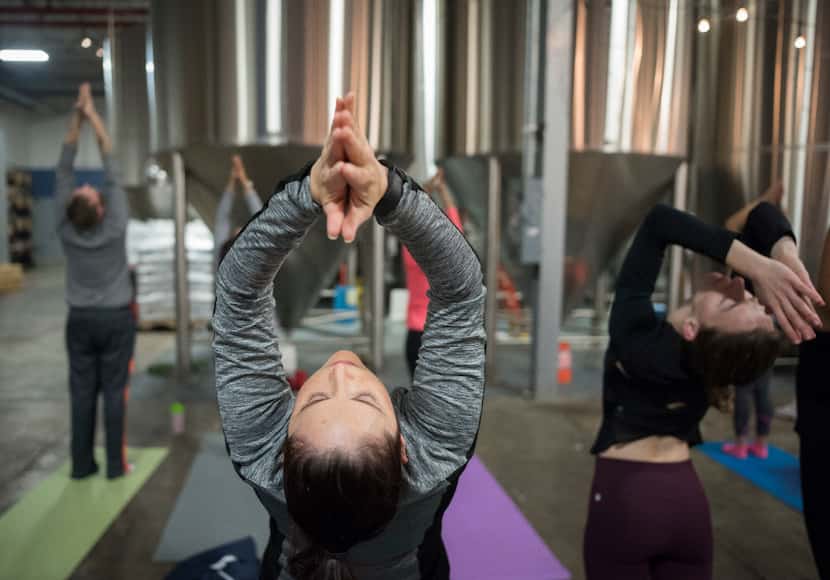 Elvira Garcia and other yoga participants take part in a class at Community Beer Company on...