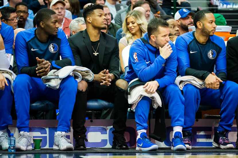 Dallas Mavericks guard Dennis Smith Jr. (second from left) watches from the bench in street...
