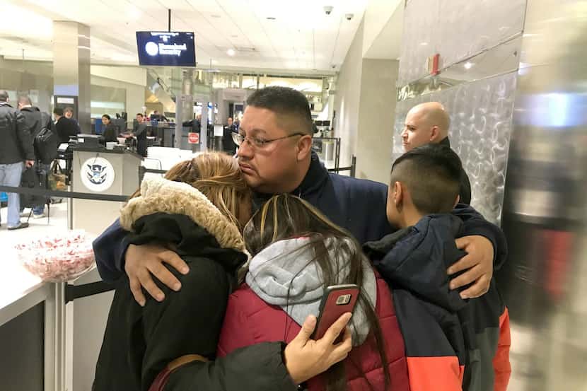 Jorge García abraza a su esposa Cindy garcía y sus dos hijos en el Detroit Metro Airport...