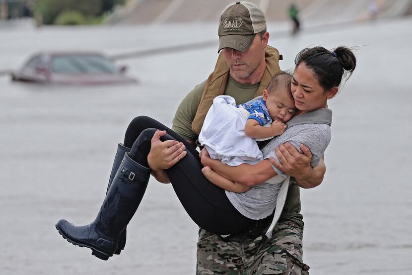 In this viral photo, Houston SWAT officer Daryl Hudeck carried Cathy Pham and then...