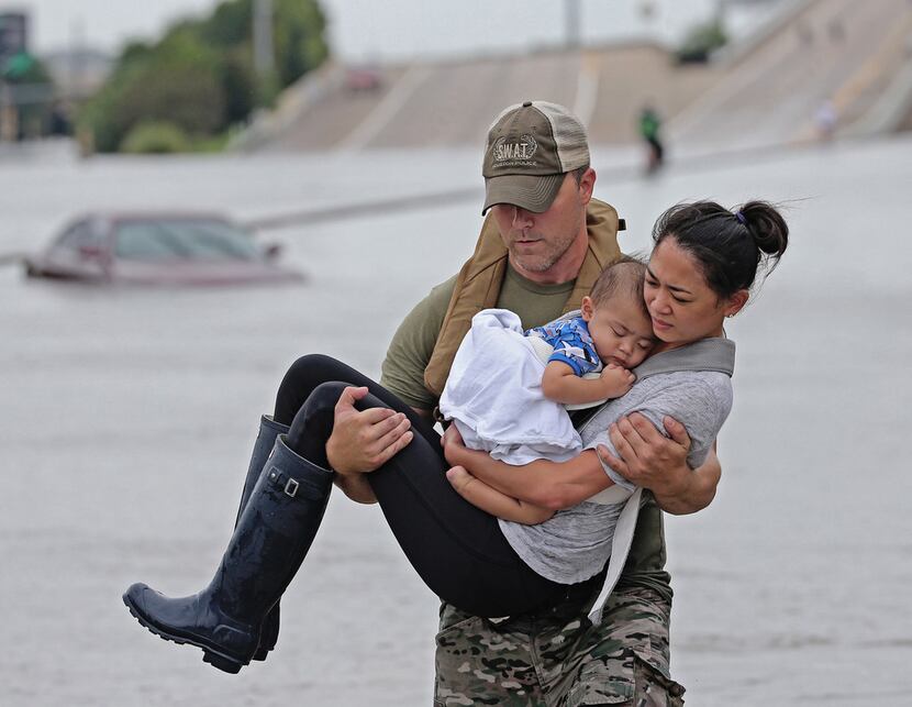 In this viral photo, Houston SWAT officer Daryl Hudeck carried Cathy Pham and then...