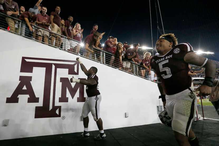 Texas A&M defensive lineman Zaycoven Henderson (92) and running back Trayveon Williams (5)...
