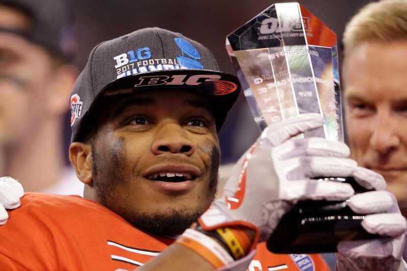 Ohio State's J.K. Dobbins holds the MVP trophy following the team's Big Ten championship...