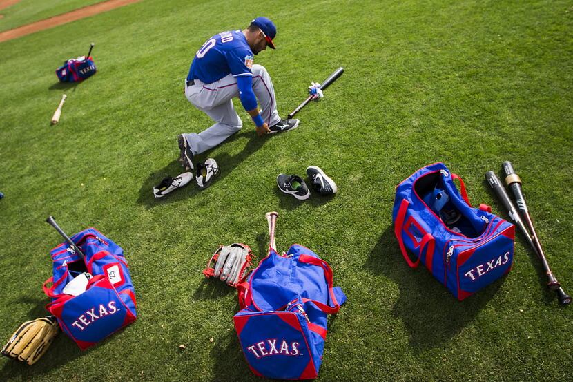 Texas Rangers player ties his shoes during a spring training workout on Thursday, March 3,...