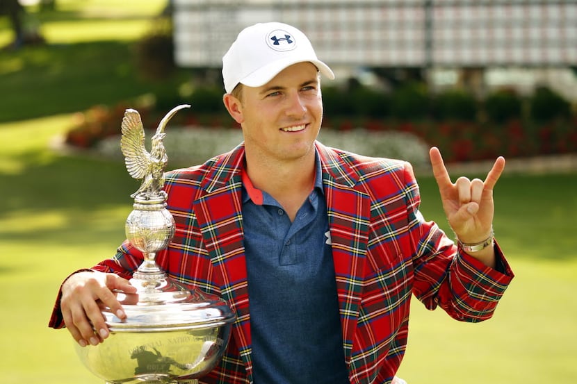 Jordan Spieth flashes the 'Hook'em Horns' sign while posing with the Marvin Leonard trophy...