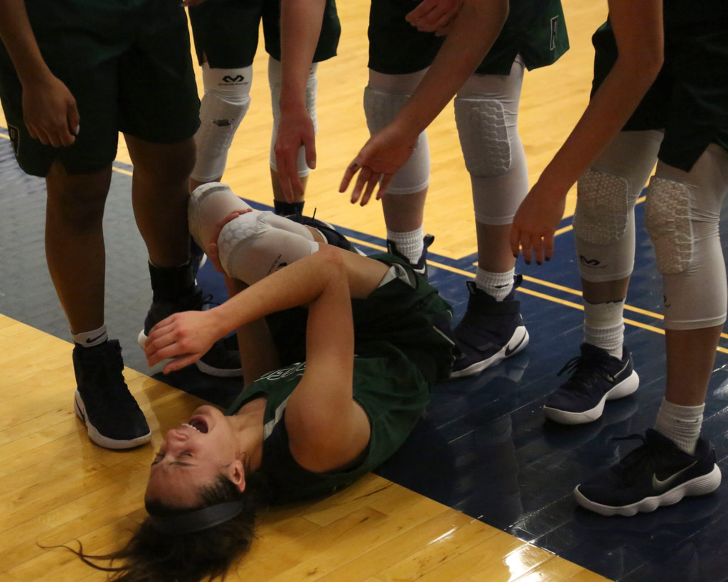 Frisco Reedy's Sophia Thomas is surrounded by teammates after she injures her leg during...