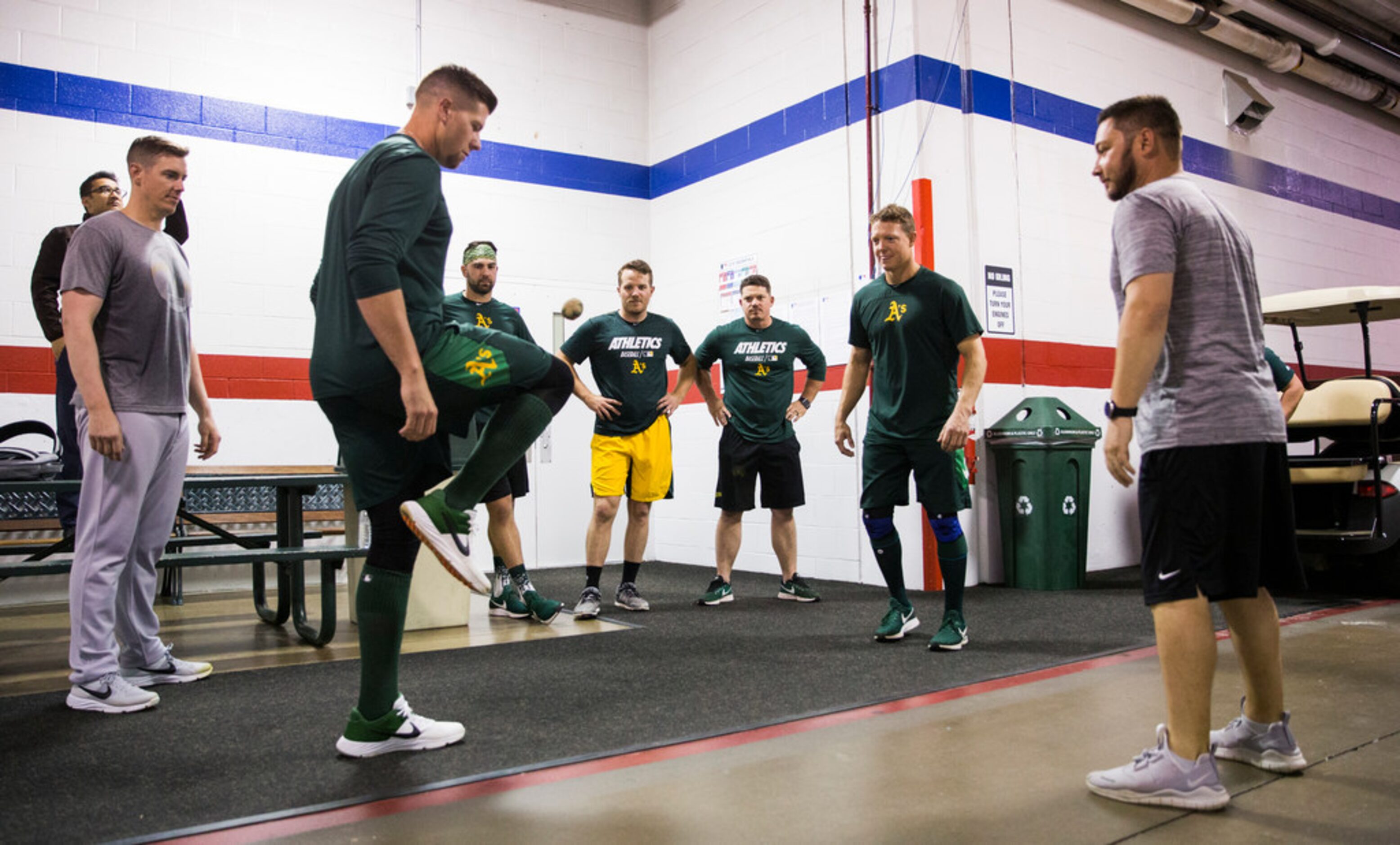 Oakland Athletics players play hacky sack in the tunnel during a rain delay at an MLB game...