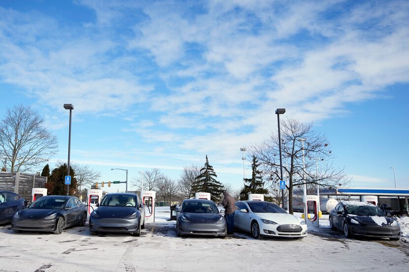 Teslas lined up at a charging station Wednesday in Ann Arbor, Mich., as EV owners...