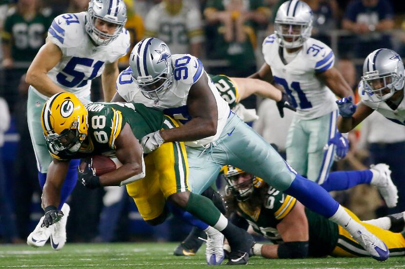 Dallas Cowboys defensive end Demarcus Lawrence (90) stops Green Bay Packers running back Ty...