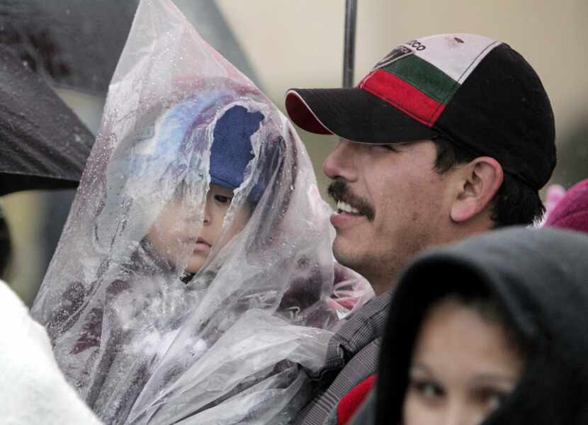 Joaquin Hernandez holds 19-month-old son Jonathan while they wait to enter the 15th...