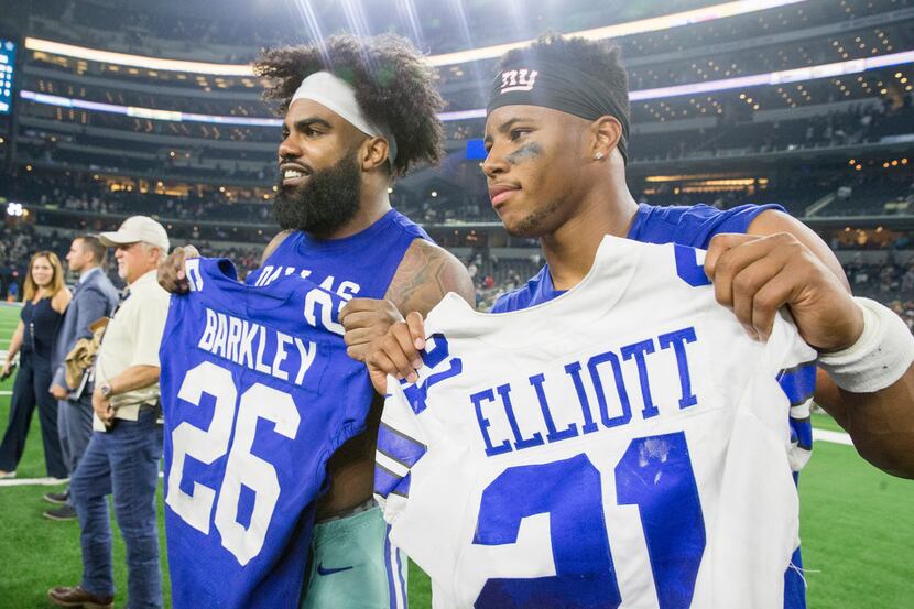 Dallas Cowboys running back Ezekiel Elliott (21) poses for pictures after exchanging jerseys...