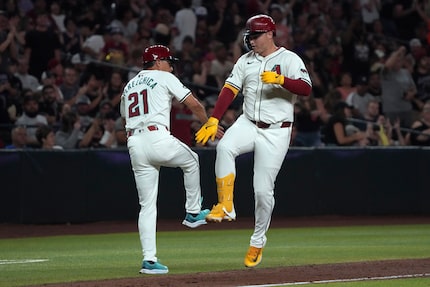 Arizona Diamondbacks' Joc Pederson celebrates with third base coach Tony Perezchica (21)...